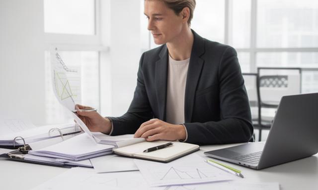 Markets reporter comparing company filings and economic indicators in a bright office
